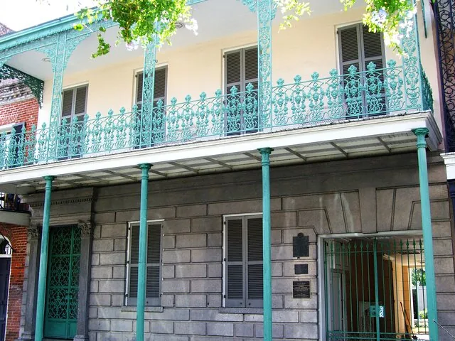 The exterior of Gallier House with its iconic green cast-iron balcony.