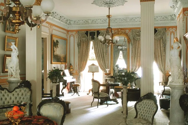 Ein reich verzierter Salon im Gallier House mit Kronleuchter und Marmorstatuen.