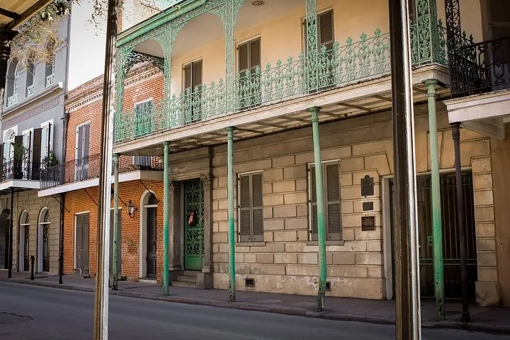Una vista de la calle que muestra la fachada y el balcón de Gallier House.