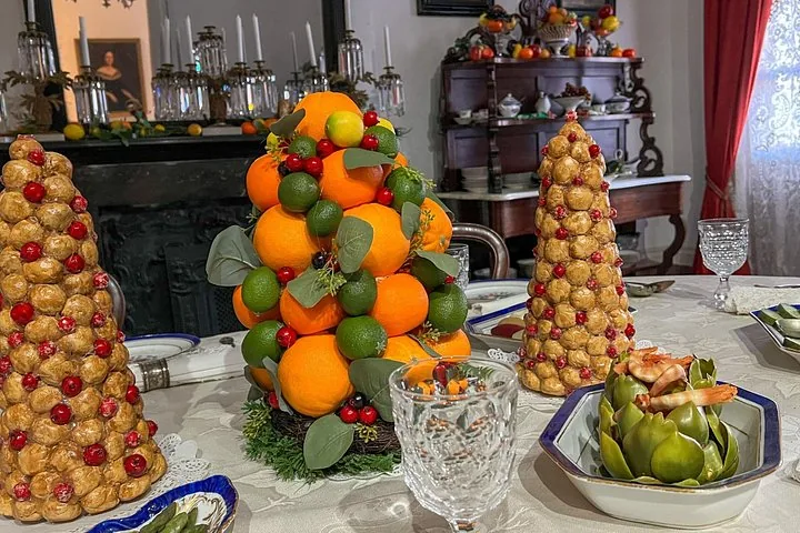Ein Esstisch mit dekorativen Lebensmittel-Gestecken, einschließlich eines Orangenturms.